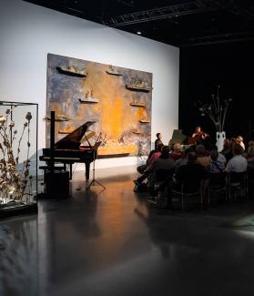 konsert i utställningen Konsert i Kiefers utställning med flygel och publik